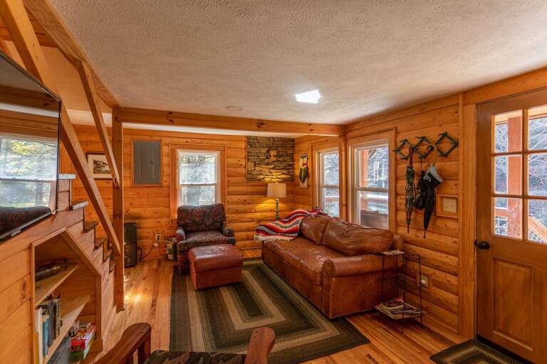 Wooden Cabin Interior With Furniture And Staircase