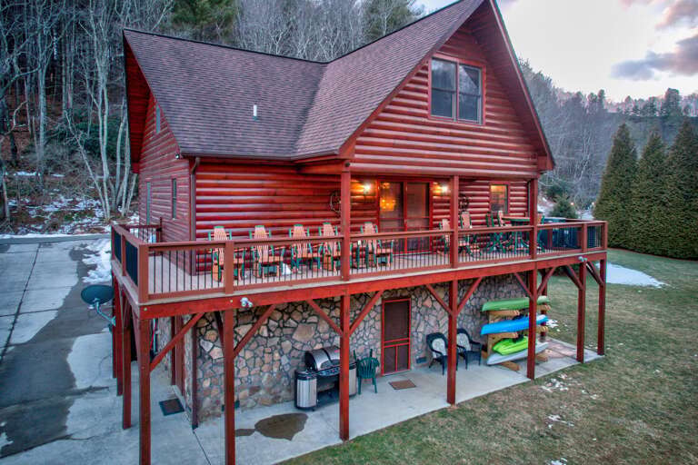 Wooden Cabin Rental With Elevated Deck And Forest Backdrop