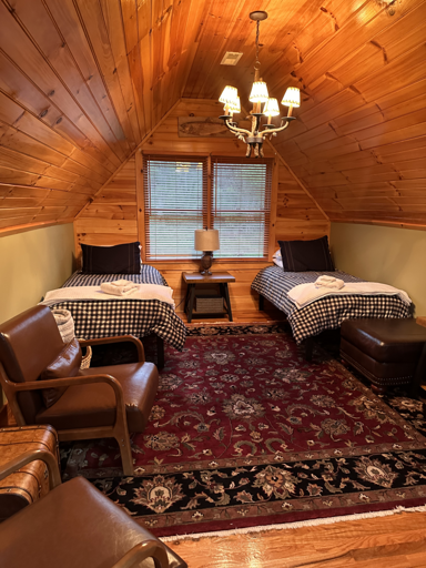 Wood-lined Room With Twin Beds, Rich Rug, Leather Seating, And Central Chandelier