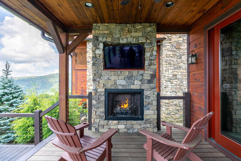 Outdoor Patio With Fireplace And Chairs Overlooking Mountains