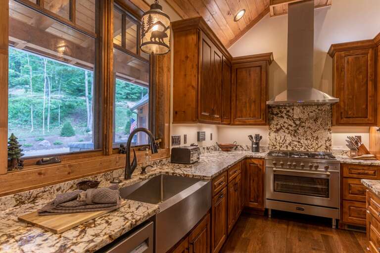 Wooden Kitchen Interior With Stainless Steel Appliances And Window View Of Trees
