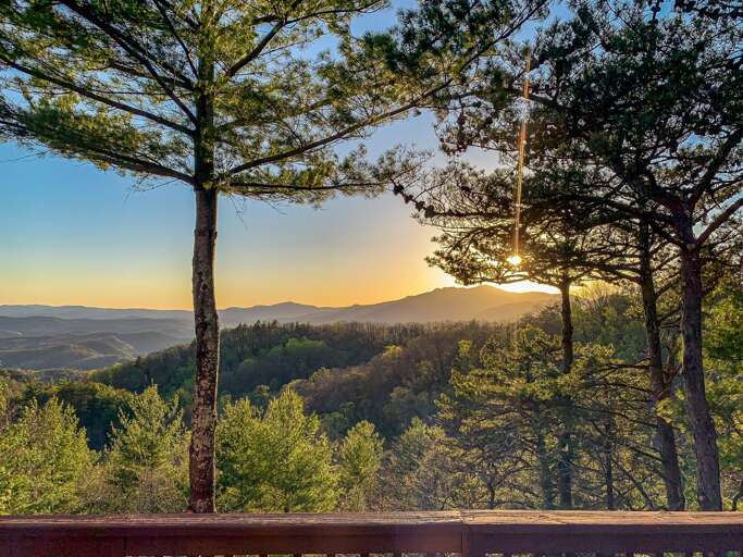 Sunset View From Balcony With Trees And Hills