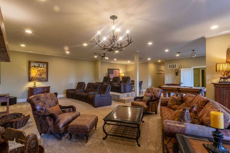 Lower level theater room and seating area with game table.