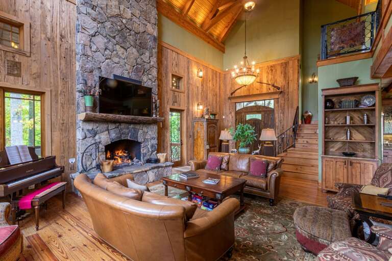 Main level living room with gas fireplace, smart TV, Sonos bar and self playing piano.