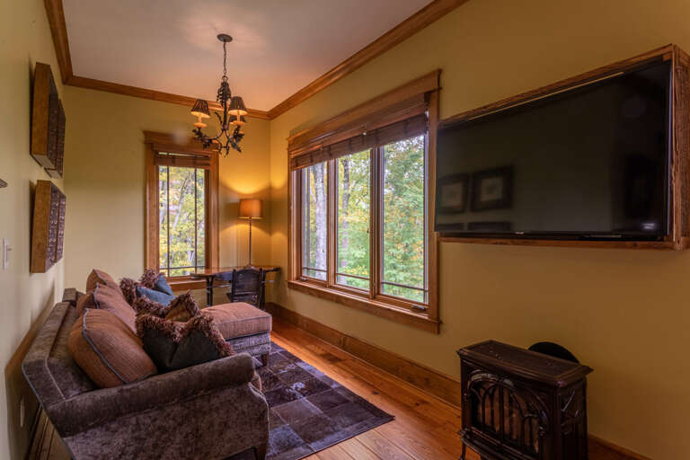 Main level master bedroom with king sized bed, smart TV, seating area and full bathroom.