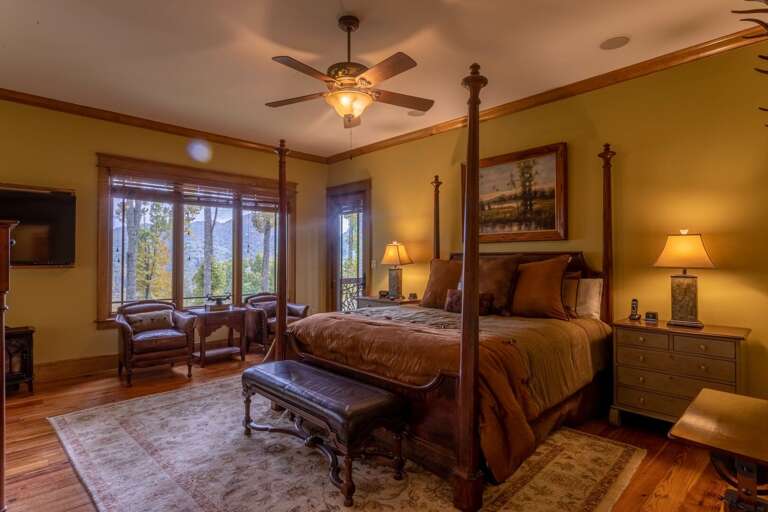 Main level master bedroom with king sized bed, smart TV, seating area and full bathroom.