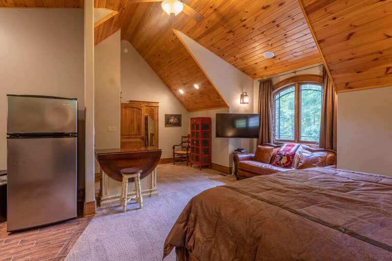 Upper level apartment with king bed, smart TV, seating area, closet, full kitchen and full bathroom.