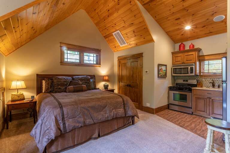 Upper level apartment with king bed, smart TV, seating area, closet, full kitchen and full bathroom.