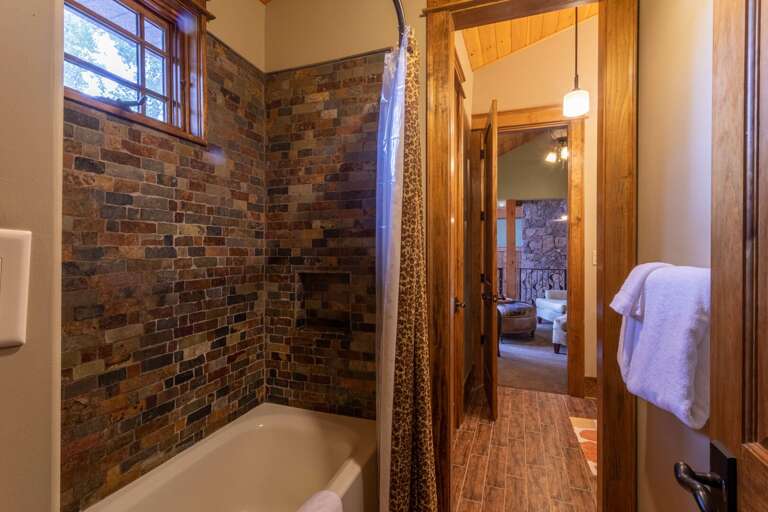 Upper level bedroom bathroom with double vanity and shower/tub combo.