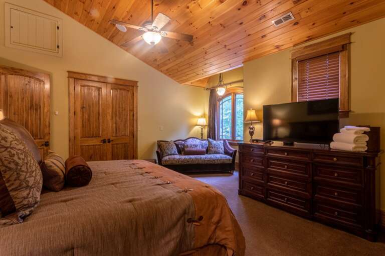 Upper level bedroom with king sized bed, smart TV, seating area, closet and full bathroom.