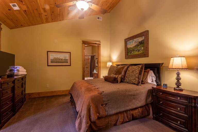 Upper level bedroom with king sized bed, smart TV, seating area, closet and full bathroom.