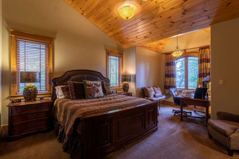 Upper level bedroom with king sized bed, smart TV, seating area, closet and full bathroom.