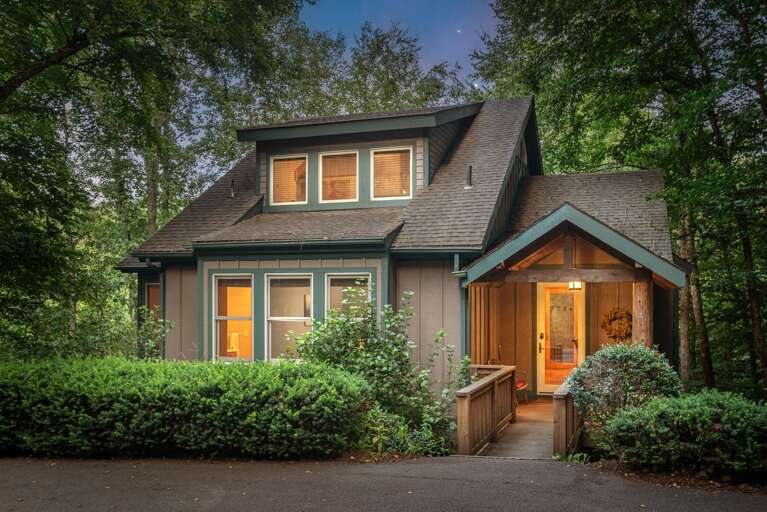 Two-story Residential House Surrounded By Trees At Dusk