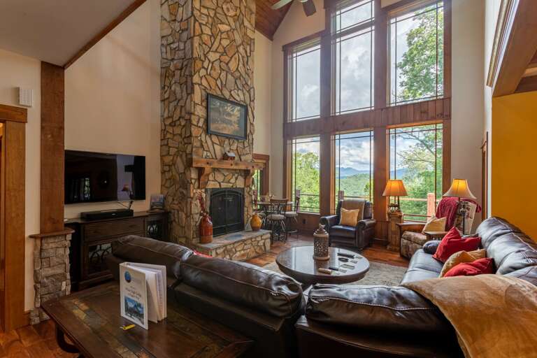 Living Room With Large Windows And Stone Fireplace