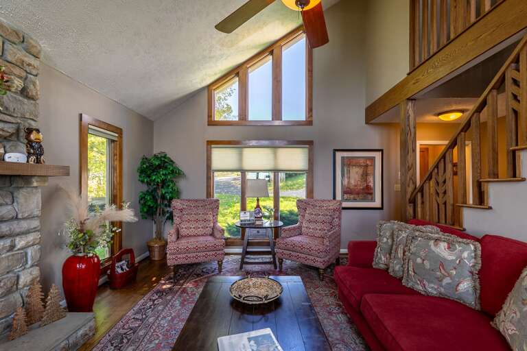 Living Room With Staircase And Stone Fireplace