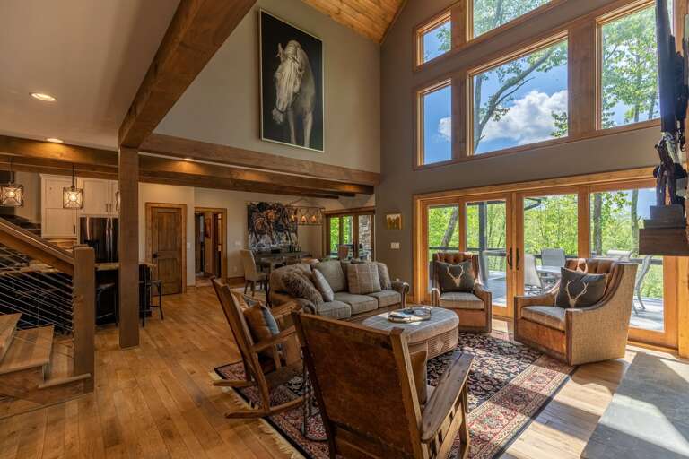 Interior Living Space With High Ceilings, Large Windows, And Wooden Details
