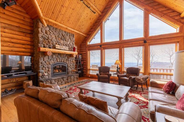 Wooden Cabin Interior With Stone Fireplace And Lake View