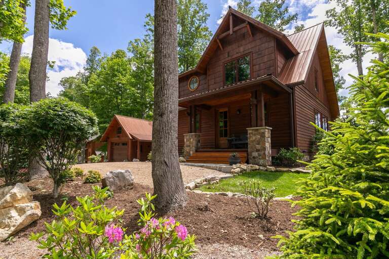 Wooden Cabin Surrounded By Trees And Garden