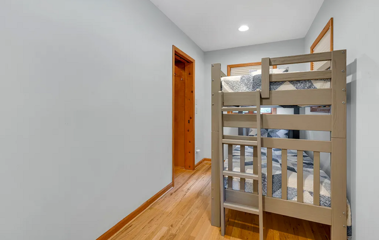Newly added bunk room tucked between the primary walk-in closet and the laundry/mud room