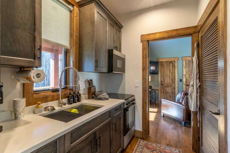 Kitchen Interior With Wooden Cabinets And Doorway Leading To Another Room