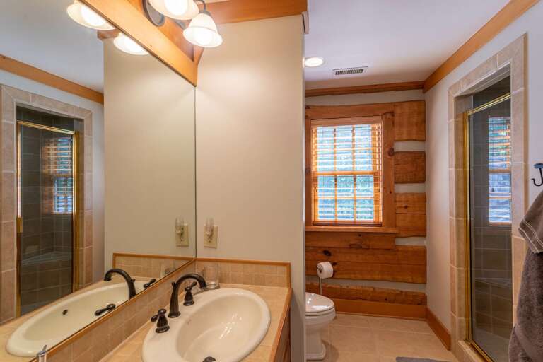 Upper level bedroom bathroom with double vanity and standing shower.