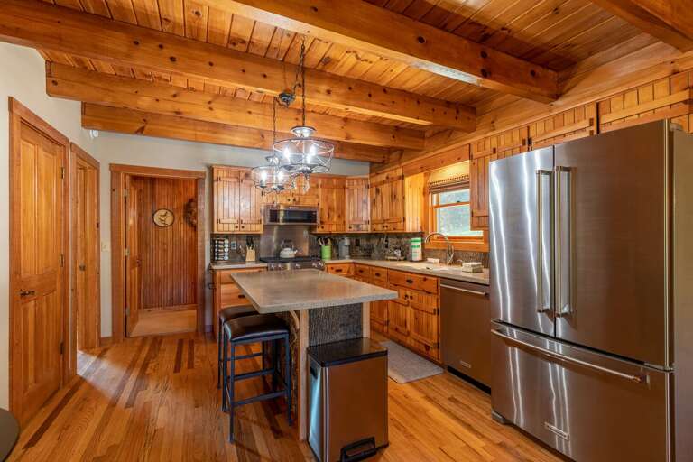 Wood-lined Kitchen With Stainless Steel Appliances And Central Island