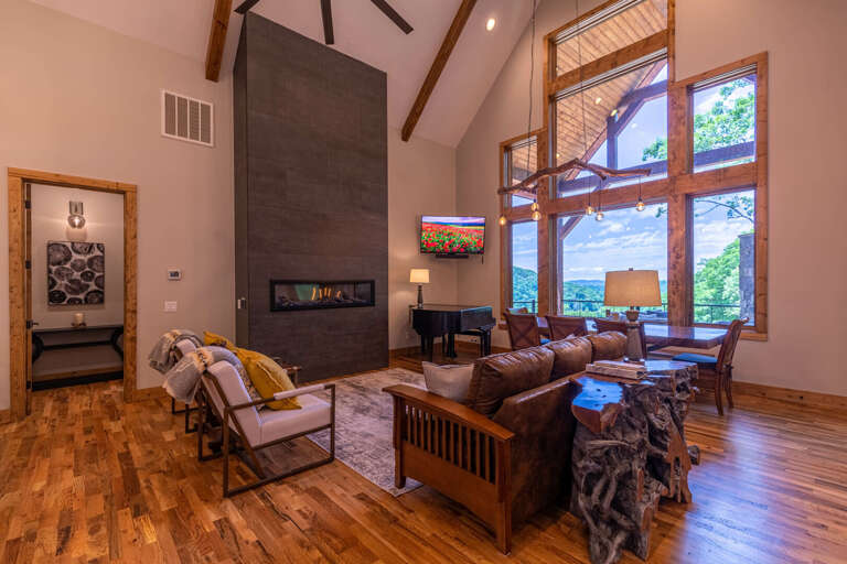 Spacious Living Space With Soaring Ceilings, Sleek Fireplace, And Towering Windows