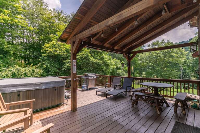 Vacation Rental Deck With Dining Area And Hot Tub Surrounded By Trees