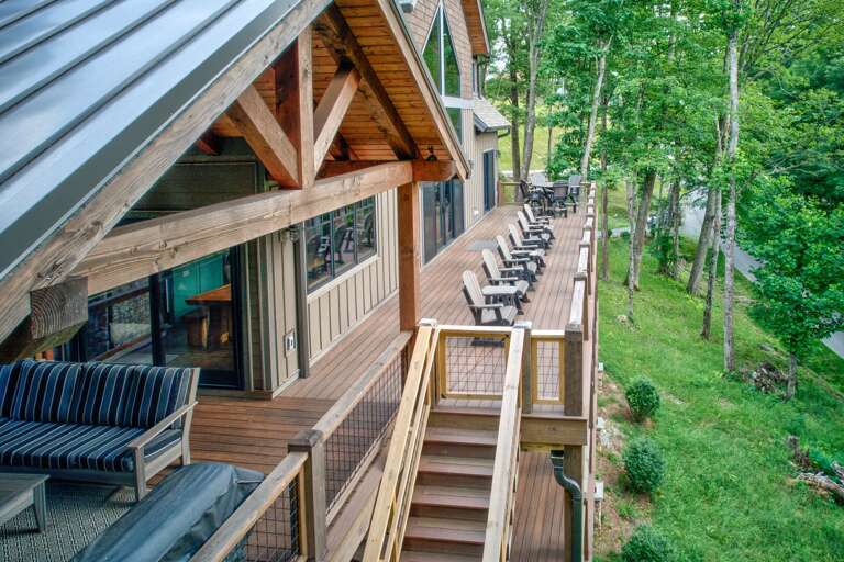 A row of Adirondack chairs lines the expansive deck, perfectly placed for kick back in the surrounding Blue Ridge woods.