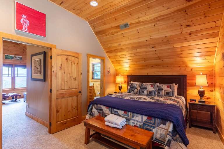 Upstairs King suite  with wooden bench and connected bathroom