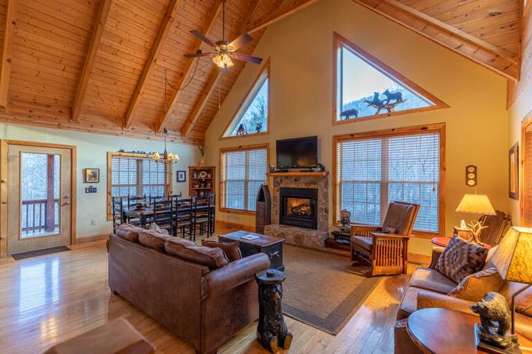 Spacious Living Room With Vaulted Ceilings, Large Windows, And Wooden Interiors