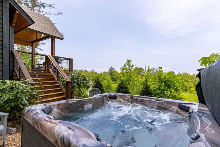 House With Hot Tub Overlooking Lush Greenery