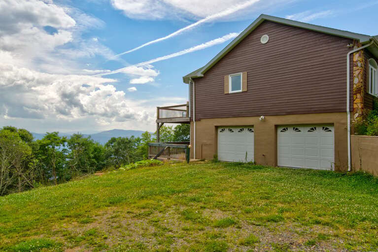Brown Building Backed By Blue Skies, Nestled Near Nature