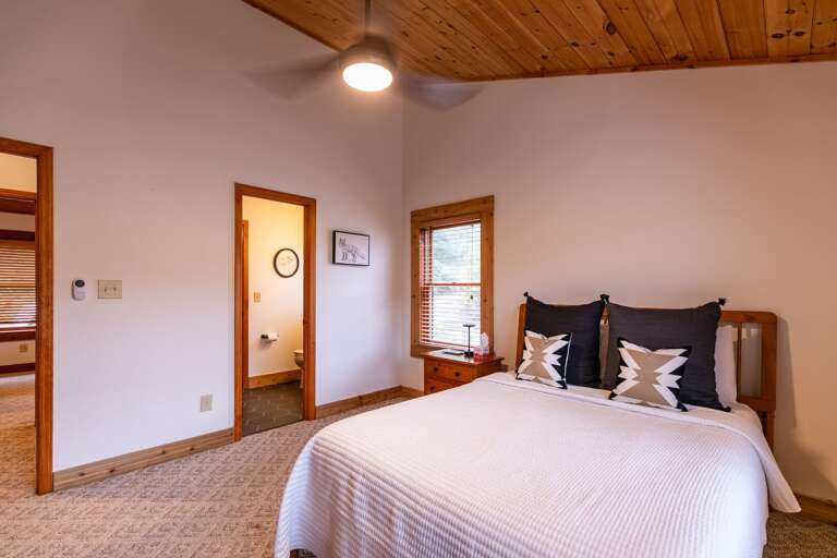 Vacation Rental Room With Wooden Walls, White Bed Linens, And A Rustic Ambience