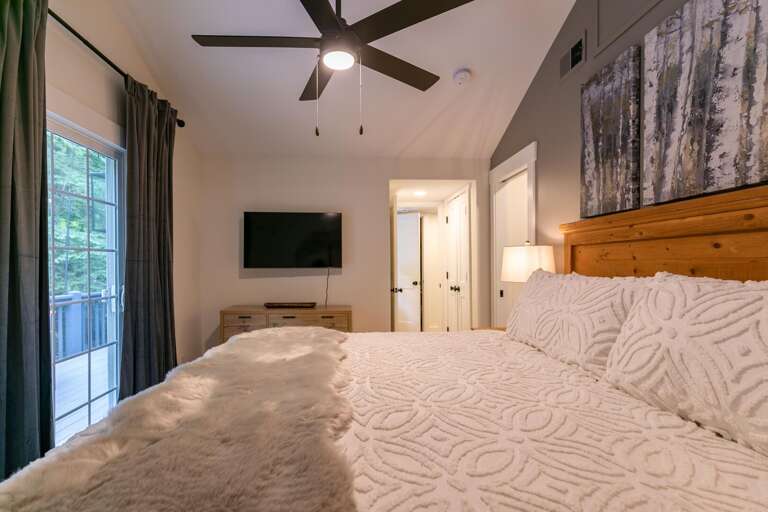 The main level primary bedroom offers a luxurious king bed and mounted tv for private relaxation