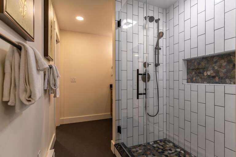The spacious custom tile shower brings together a modern finish with Nature.