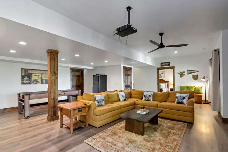 Basement gathering space with refrigerator and stocked game closet