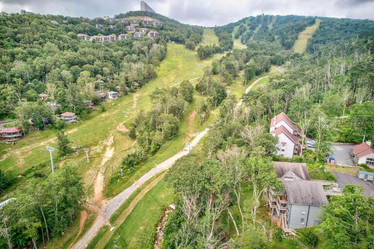 Lush Landscape With Winding Roads And Scattered Structures Nestled In Verdant Hills