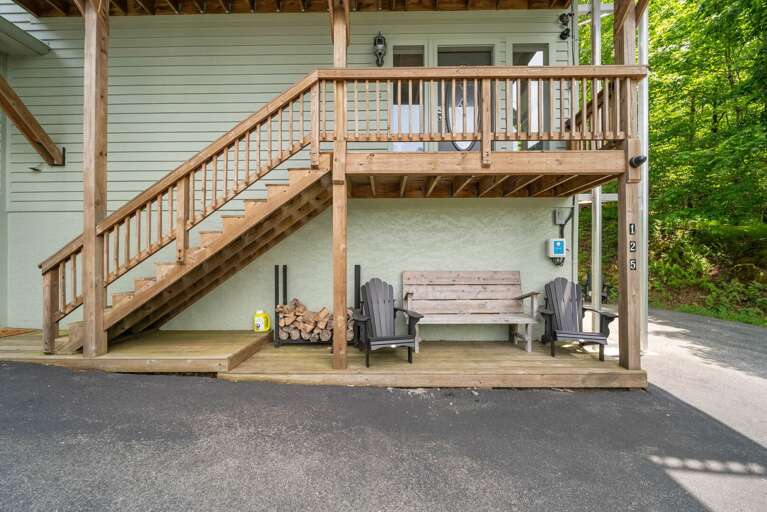 Wooden Walk-up With Chairs Under Shaded Structure Surrounded By Greenery