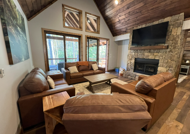 Rustic Rental Retreat Room With Stone Fireplace And Vaulted Wooden Ceilings