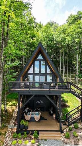 Tucked into the trees of Boone, this striking A-frame welcomes you with a soaring glass facade and a shaded lower patio with a hot tub.