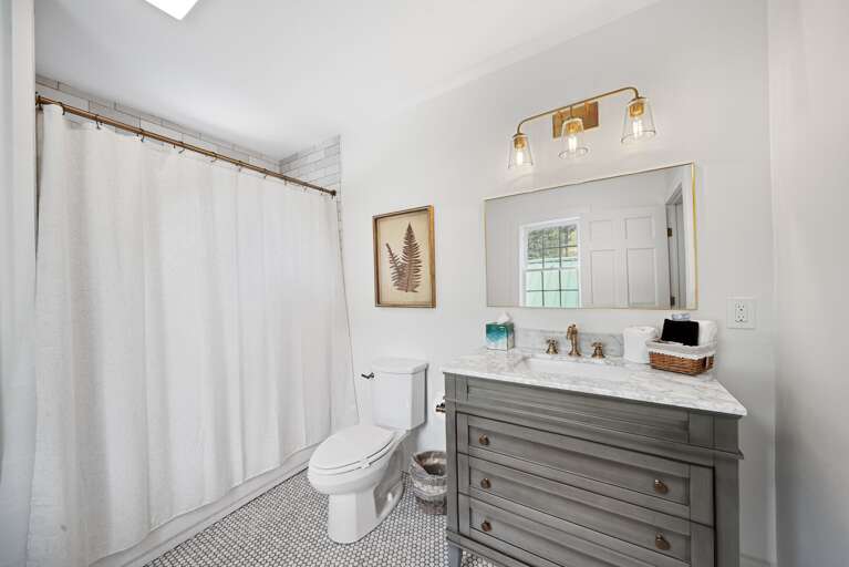 Bright Bathroom With White Walls, Window, And Wooden Cabinet