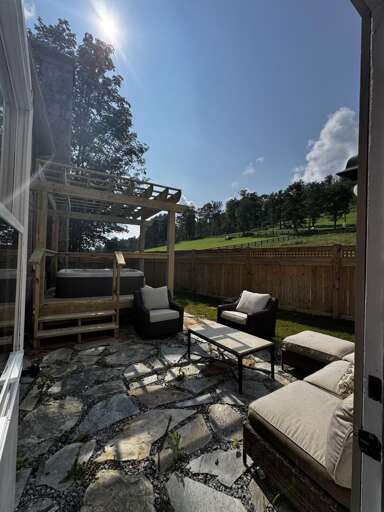 Relax in the hot tub under the pergola in the private backyard patio at The Pink House!