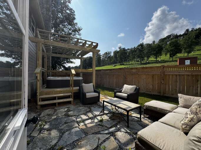 Relax in the hot tub under the pergola in the private backyard patio at The Pink House!
