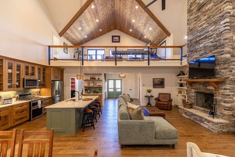 Spacious Living Space With Stone Fireplace And Lofted Ceiling