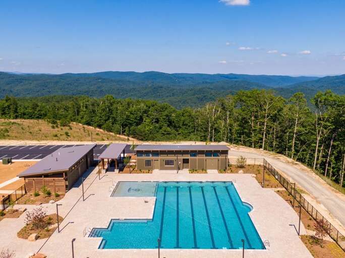 Aerial View Of Blue Pool And Patio Beside Lush Landscape