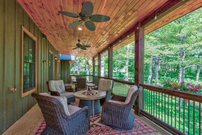 String lights, ceiling fans, and cozy wicker seating make this covered deck at The Sugar Chalet a favorite spot morning or night.