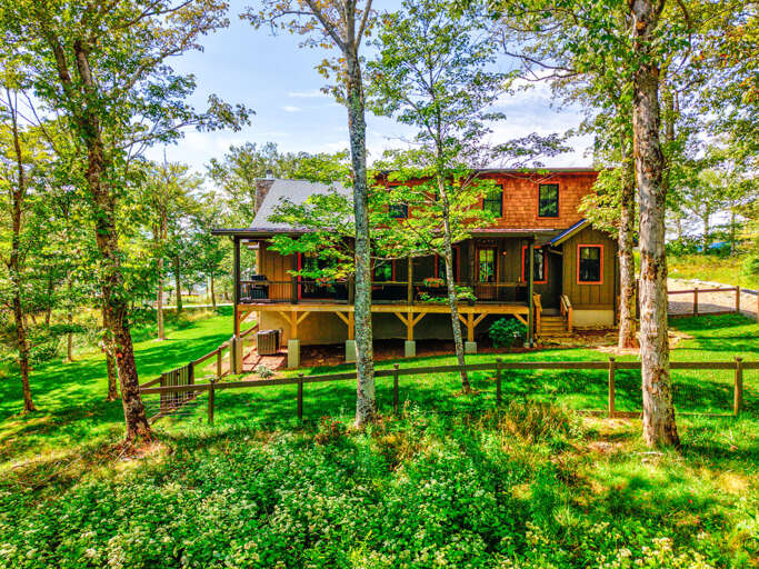 Tucked among the trees with a wraparound covered porch and warm cedar shake siding, The Sugar Chalet welcomes you to the mountains.