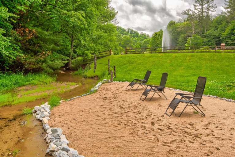 Creekside beach with a soaring fountain and the iconic red barn. Pure Blue Ridge charm.