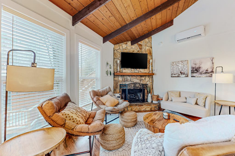 There's ample seating at The Beech Hut for everyone to relax and enjoy each other's company! Two couches and two chairs are arranged around the stone fireplace.